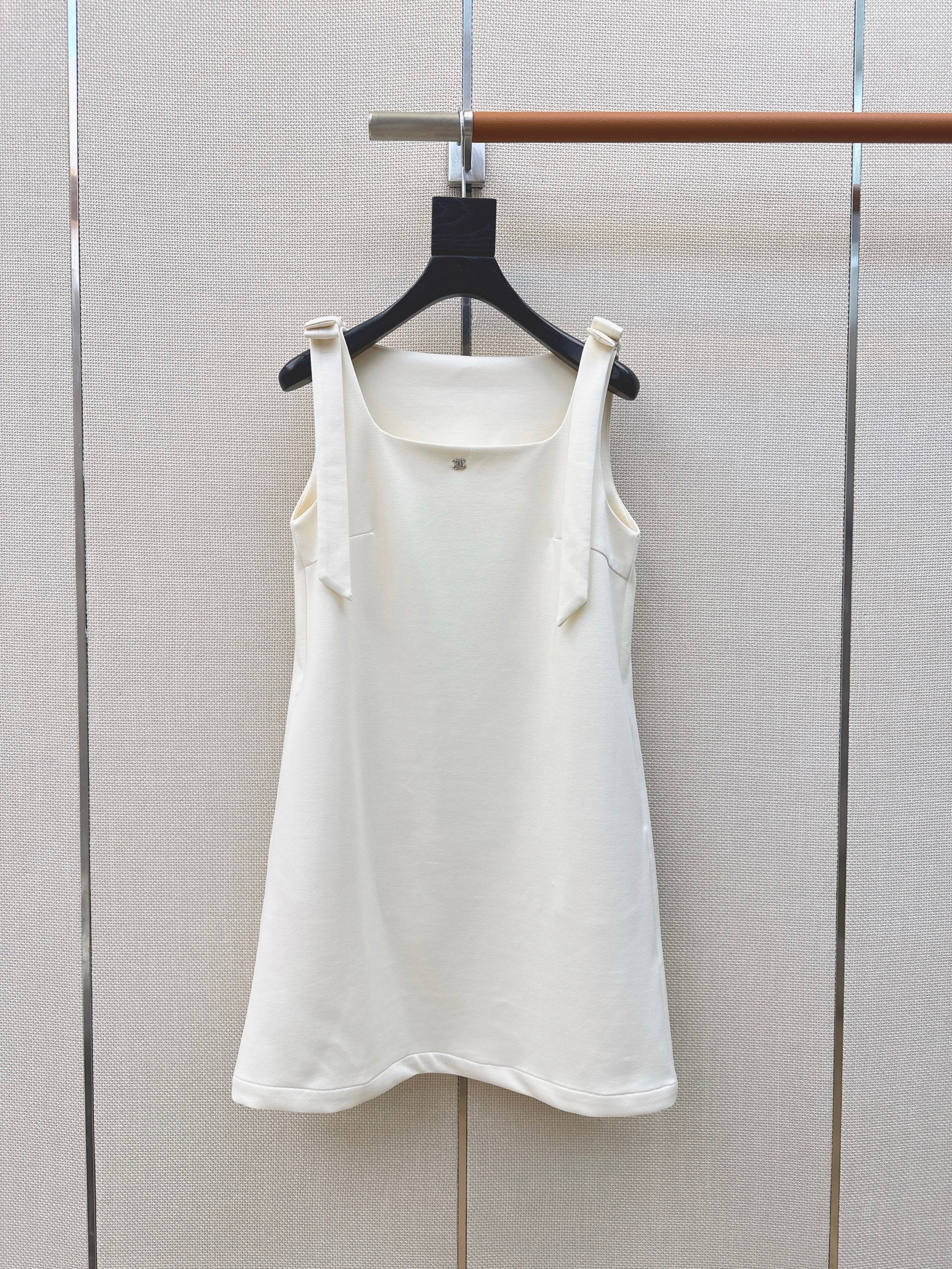 Sleeveless dress with bow-tie shoulder straps